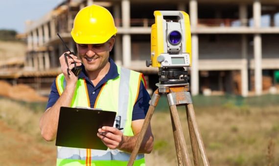 Topographer using a walkie talkie on a construction site.