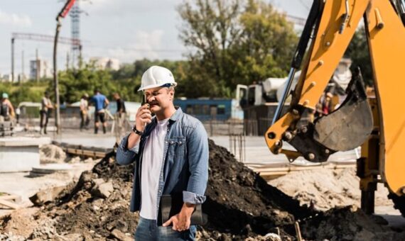 Engineer holding an walkie talkie on a construction site.