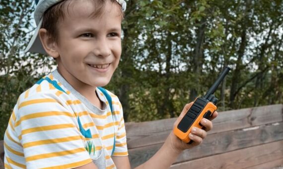 Young kid playing games with a walkie talkie.