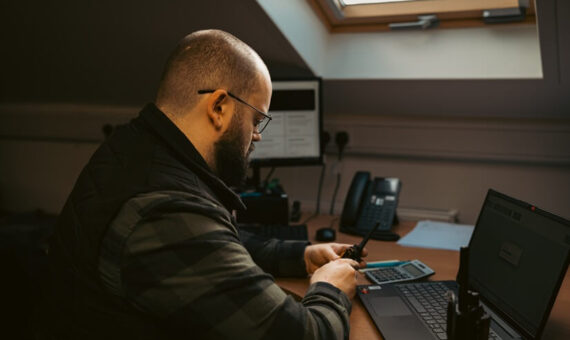 Man checking a walkie talkie battery at an office desk