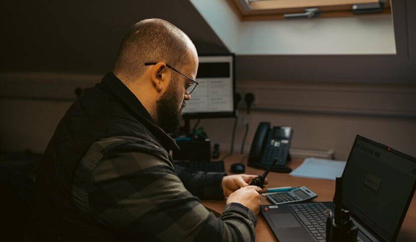 Man checking a walkie talkie battery at an office desk